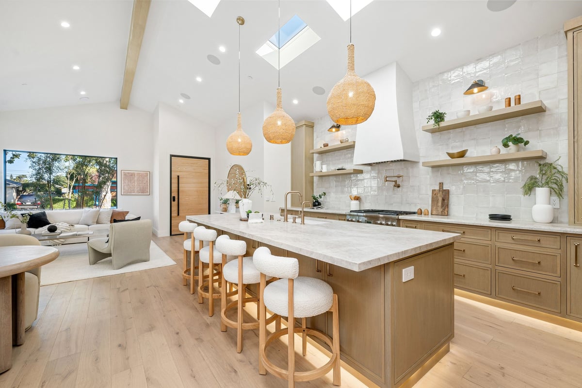 Modern kitchen interior with wooden cabinets, island, and pendant lights